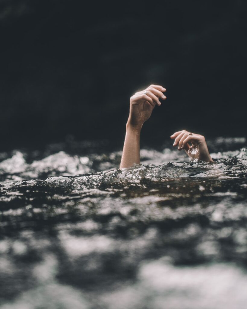 person's hands emerging from under water
